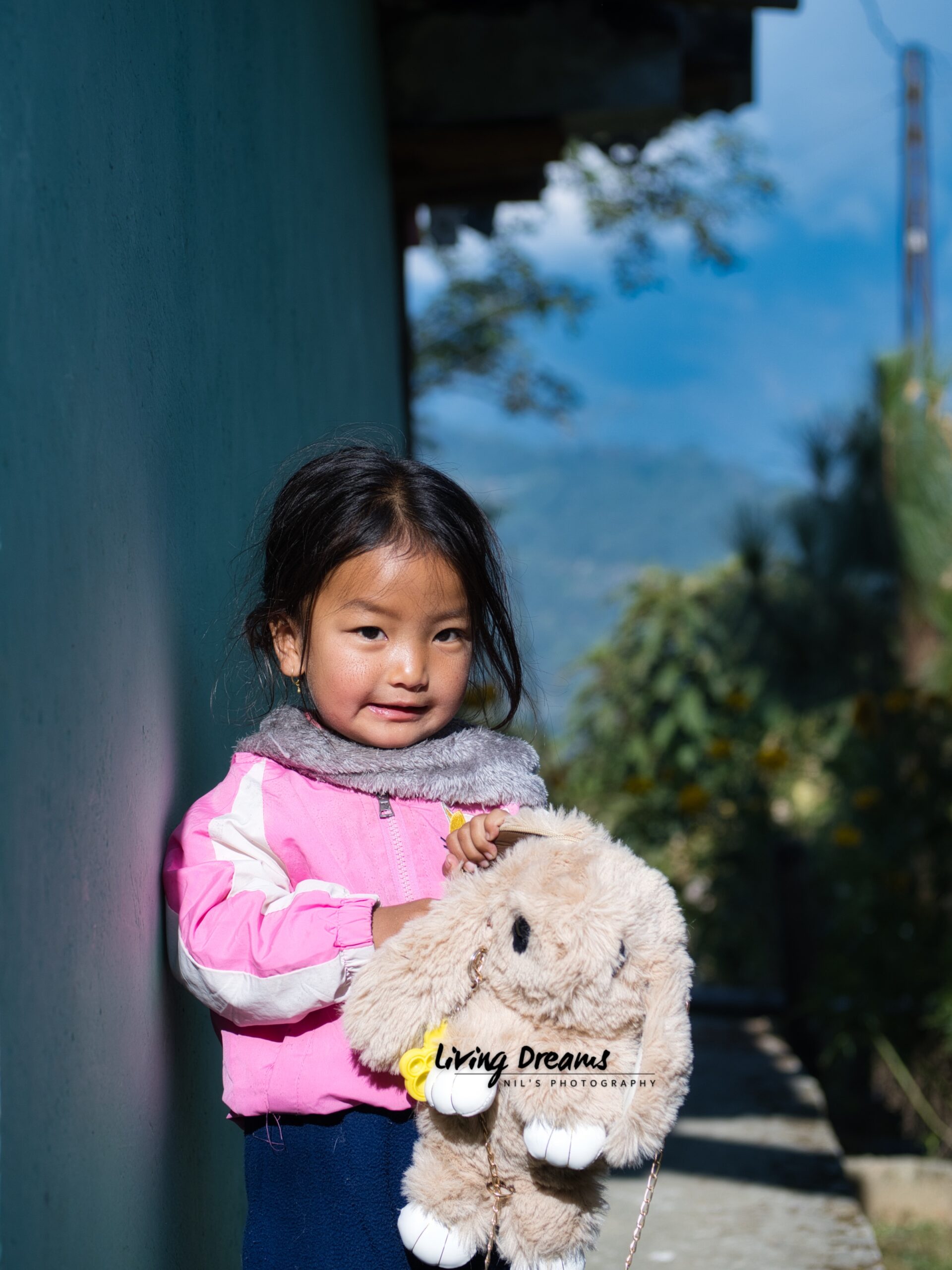 Child candid shot holding stuffed toy at sunrise, at Sikkim